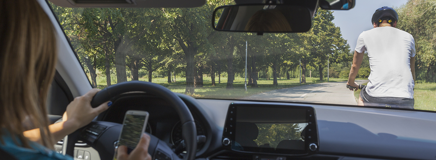 distracted driver on phone following a bicyclist